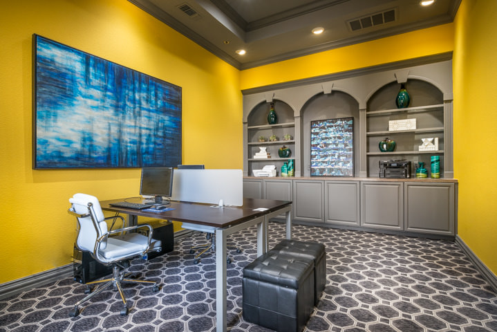 Imagen de despacho actual grande con paredes amarillas, moqueta y escritorio independiente