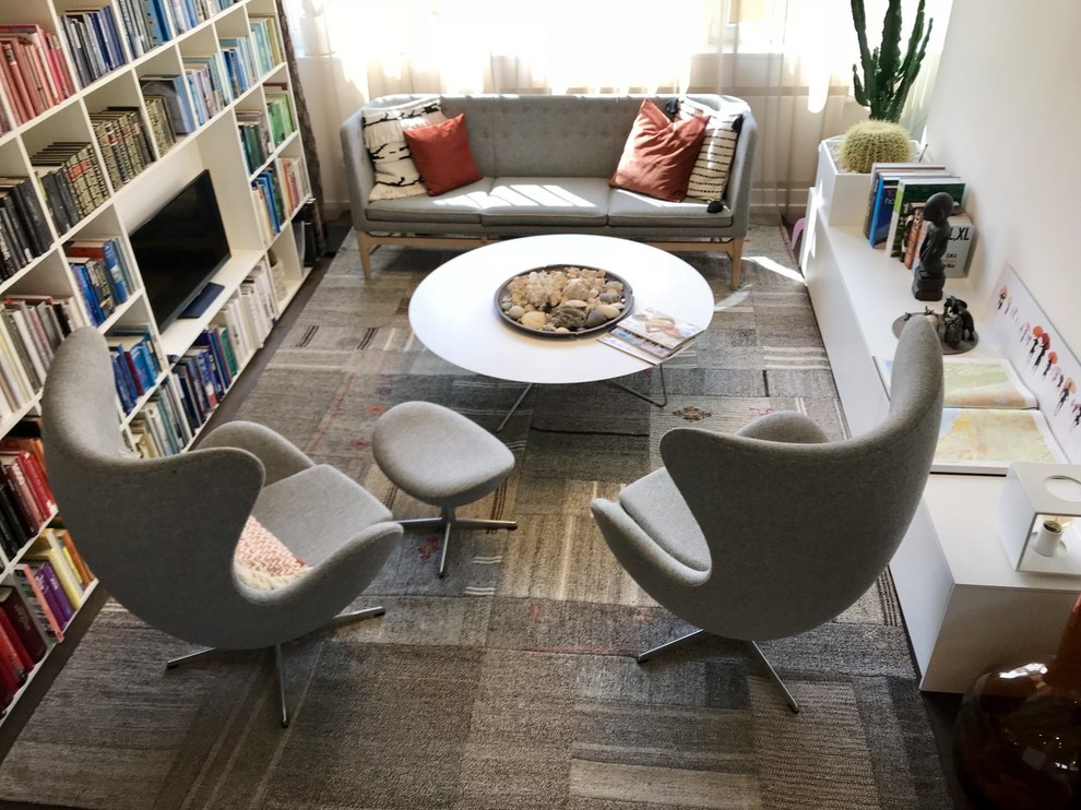Cette photo montre un bureau tendance de taille moyenne avec une bibliothèque ou un coin lecture, un mur blanc, moquette, un bureau indépendant et un sol gris.