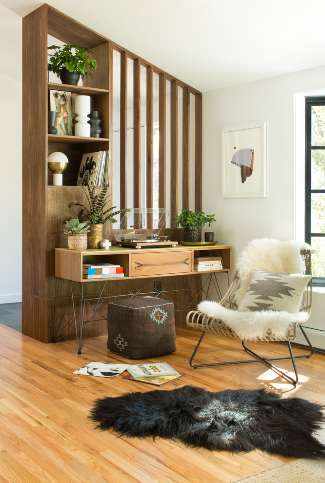 Modelo de despacho vintage con paredes blancas, suelo de madera clara y escritorio independiente