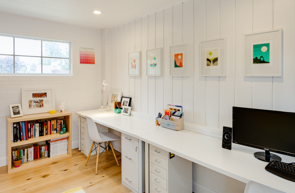 This is an example of a farmhouse home office in Phoenix with white walls, medium hardwood flooring and a freestanding desk.