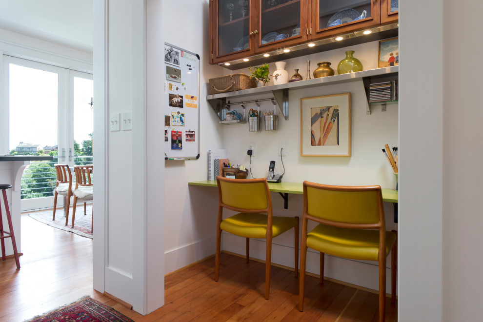 Kleines Klassisches Arbeitszimmer mit weißer Wandfarbe, braunem Holzboden, Einbau-Schreibtisch und braunem Boden in Seattle