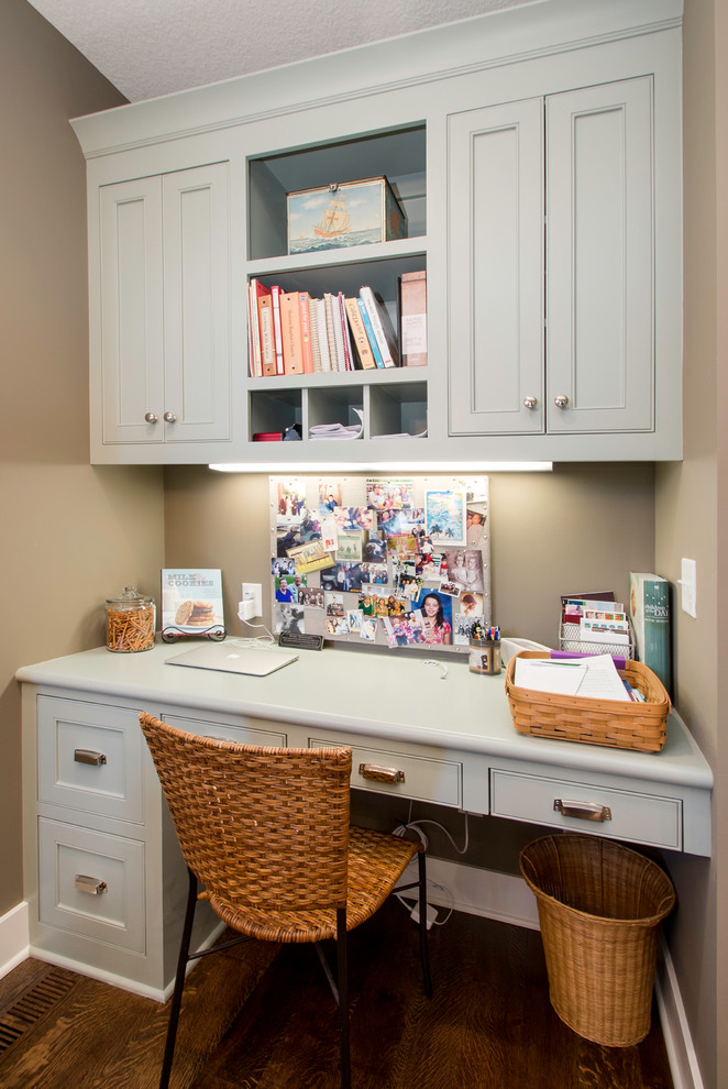 Imagen de despacho de estilo americano pequeño con paredes beige, suelo de madera en tonos medios y escritorio empotrado