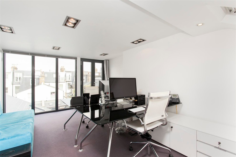 Modernes Arbeitszimmer mit weißer Wandfarbe, Teppichboden und freistehendem Schreibtisch in London