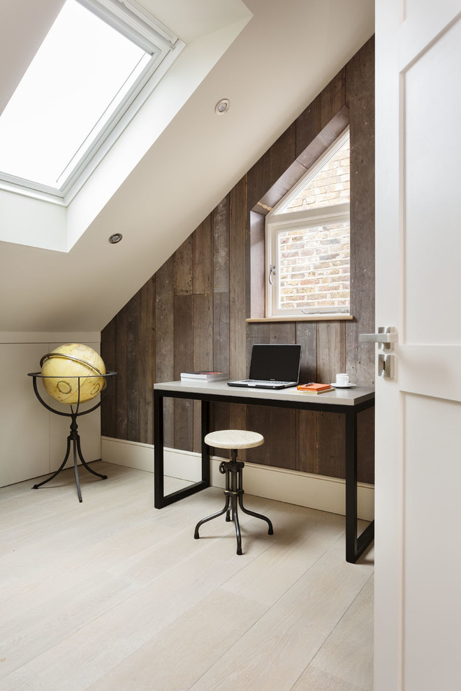 Inredning av ett modernt arbetsrum, med vita väggar, ljust trägolv och ett fristående skrivbord