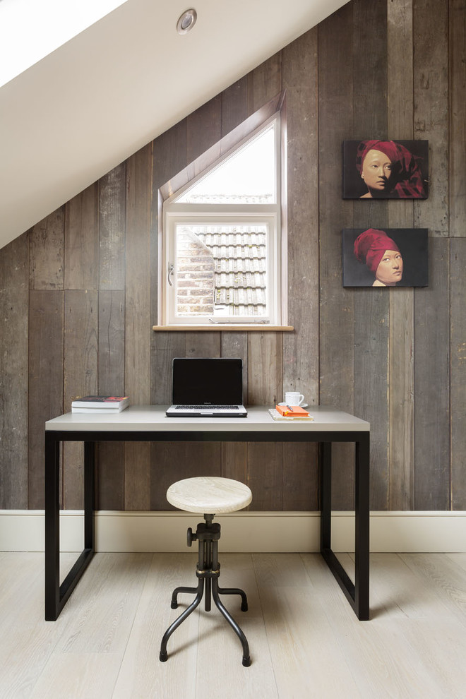 This is an example of a contemporary home office in London with light hardwood flooring and a freestanding desk.