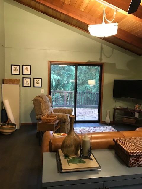 Imagen de despacho actual de tamaño medio con paredes verdes, suelo de madera oscura, estufa de leña, escritorio independiente y suelo marrón