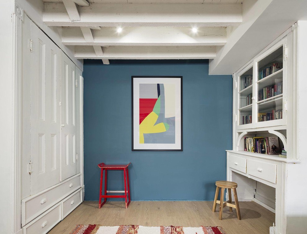 Idéer för att renovera ett mellanstort vintage arbetsrum, med ett bibliotek, blå väggar, ljust trägolv, ett inbyggt skrivbord och brunt golv