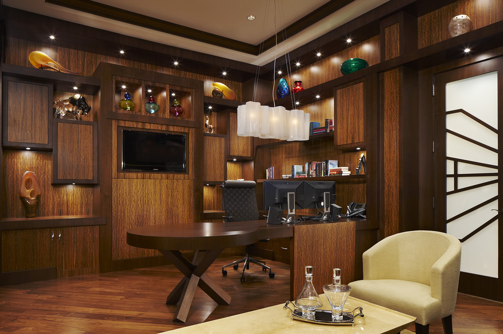 Großes Modernes Arbeitszimmer ohne Kamin mit dunklem Holzboden, Einbau-Schreibtisch und brauner Wandfarbe in Miami