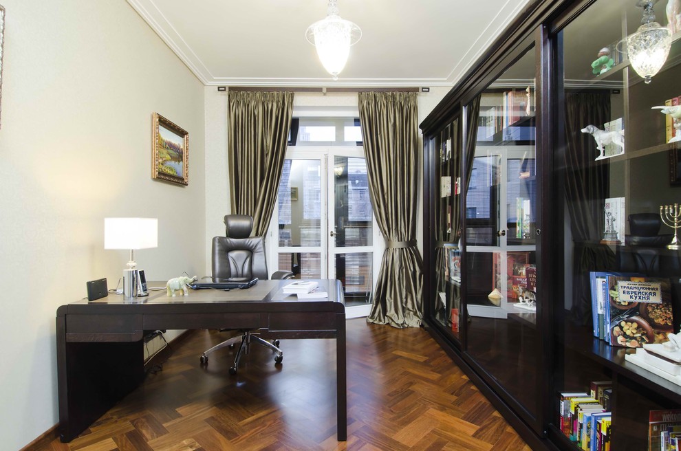 Ejemplo de despacho ecléctico grande con suelo de madera oscura, escritorio independiente, paredes verdes y suelo marrón