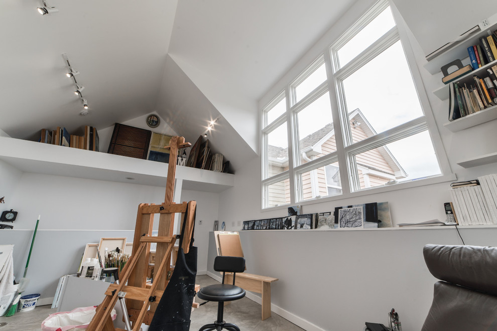 Diseño de sala de manualidades minimalista grande con paredes multicolor, suelo de cemento, escritorio independiente y suelo gris