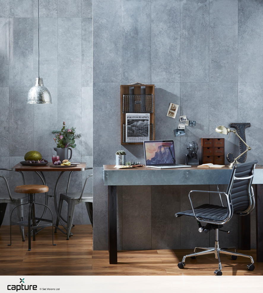Esempio di un piccolo atelier industriale con pareti grigie, pavimento in legno massello medio e scrivania incassata