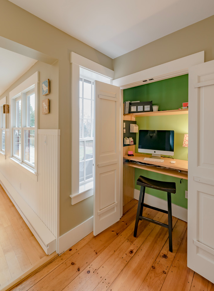 Kleines Landhausstil Arbeitszimmer mit grüner Wandfarbe, Einbau-Schreibtisch, braunem Boden, braunem Holzboden und Arbeitsplatz in Boston