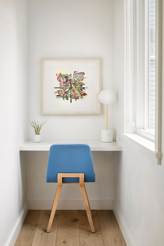 Ejemplo de despacho nórdico pequeño sin chimenea con paredes blancas, suelo de madera clara y escritorio empotrado