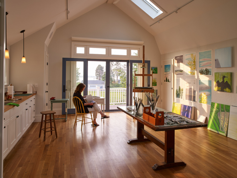 Photo of a coastal home studio in Portland Maine with beige walls, medium hardwood flooring and a freestanding desk.