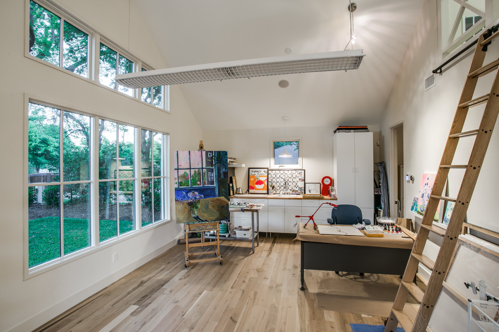 Großes Modernes Arbeitszimmer ohne Kamin mit Studio, weißer Wandfarbe, hellem Holzboden und freistehendem Schreibtisch in Dallas