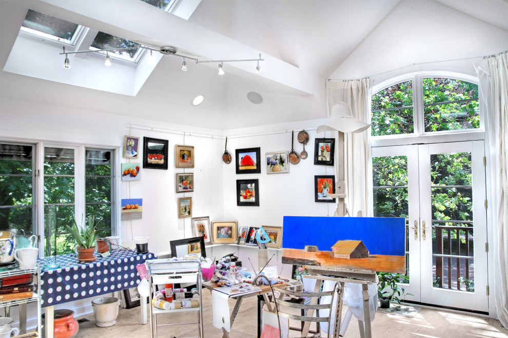 Immagine di un atelier chic di medie dimensioni con pareti bianche, scrivania autoportante, parquet chiaro e nessun camino
