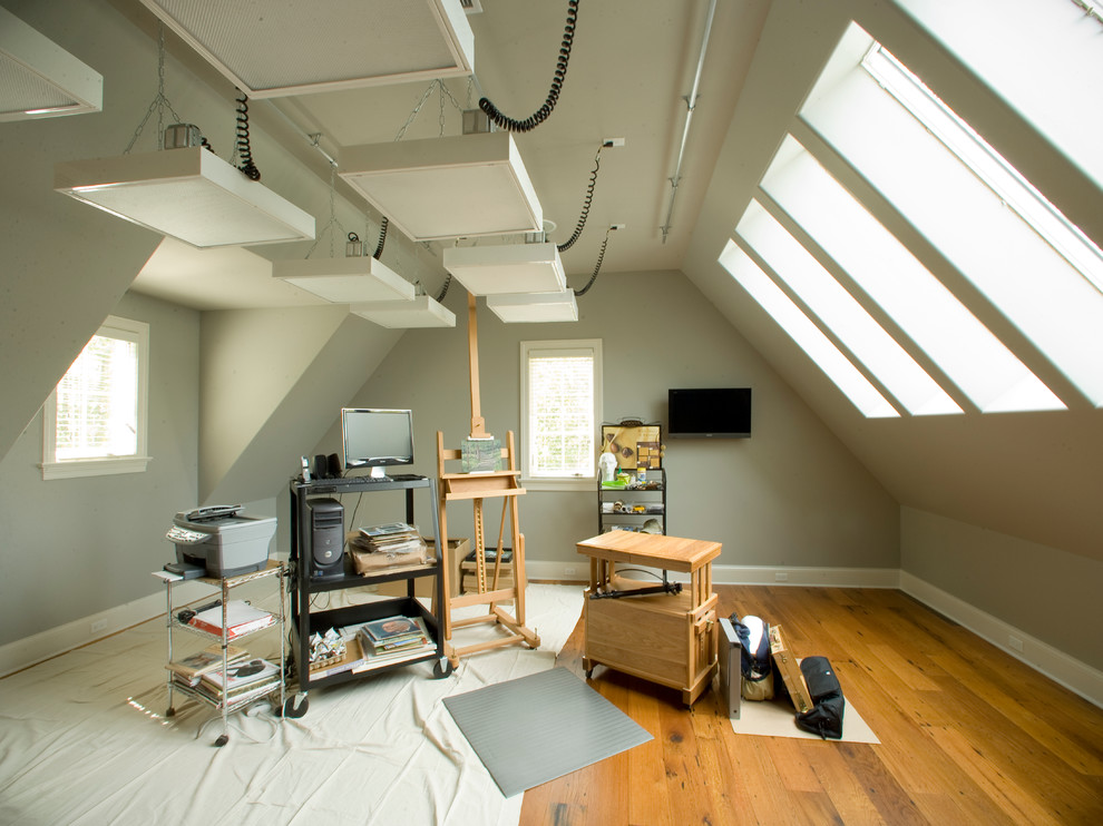 Ejemplo de estudio actual con paredes beige, suelo de madera en tonos medios, escritorio independiente y suelo marrón