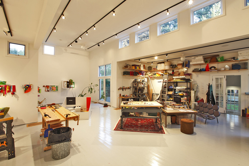 Foto di un ampio atelier minimalista con pareti bianche, pavimento in legno verniciato e pavimento bianco
