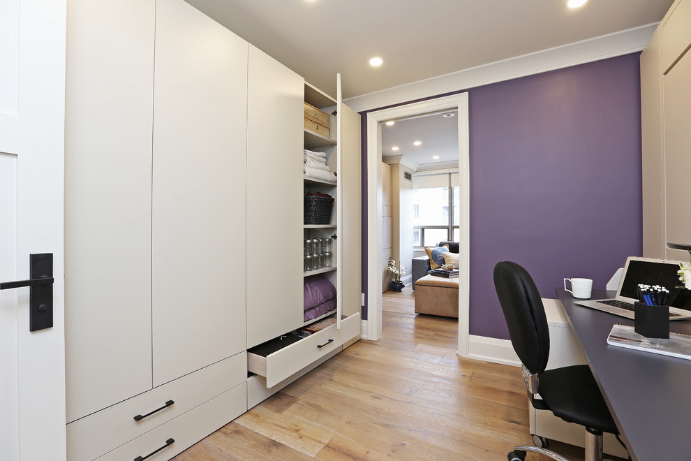 Klassisches Arbeitszimmer ohne Kamin mit lila Wandfarbe, hellem Holzboden und Einbau-Schreibtisch in Toronto
