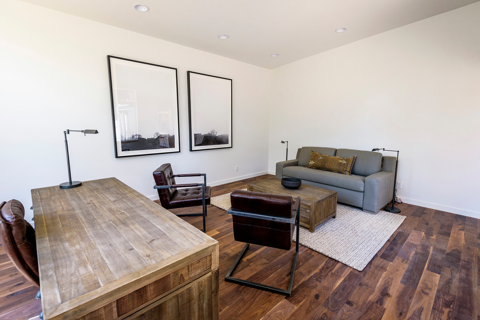 Imagen de despacho minimalista grande con paredes blancas, suelo de madera oscura, escritorio independiente y suelo marrón
