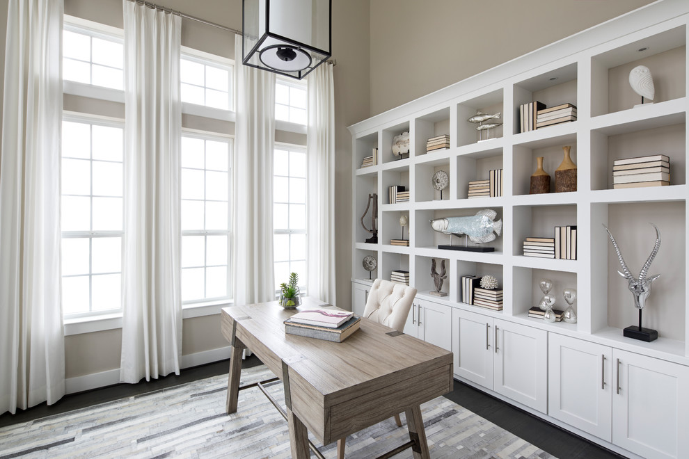 Imagen de despacho clásico renovado con paredes beige, escritorio independiente y suelo negro