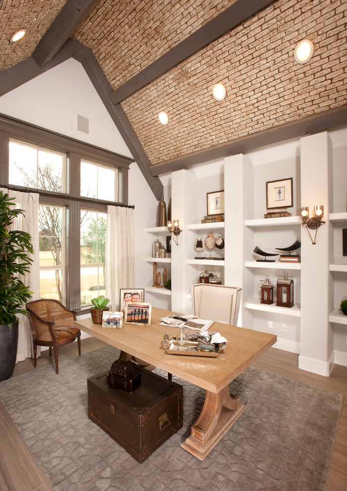 Ejemplo de despacho clásico renovado grande con paredes blancas, suelo de madera clara y escritorio independiente