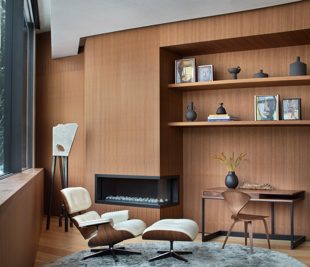 Immagine di uno studio contemporaneo con pareti marroni, pavimento in legno massello medio, camino lineare Ribbon, scrivania autoportante e pavimento marrone