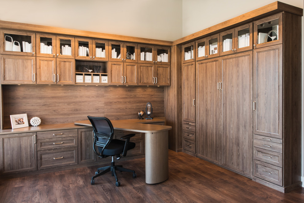 Diseño de despacho tradicional renovado extra grande con biblioteca, paredes beige, escritorio empotrado, suelo marrón y suelo de madera oscura