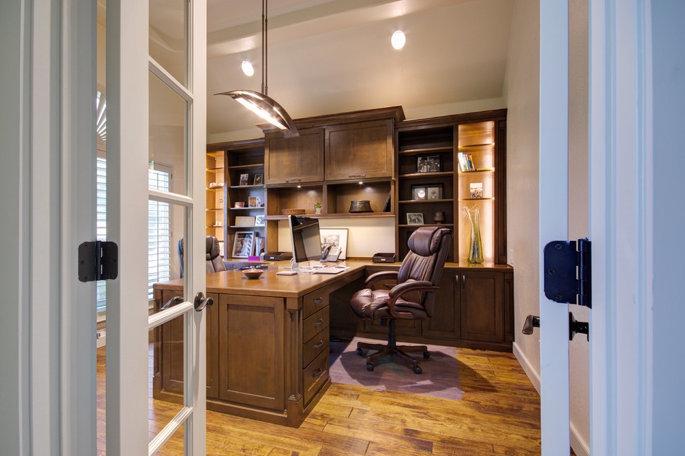 Mittelgroßes Uriges Arbeitszimmer ohne Kamin mit Arbeitsplatz, beiger Wandfarbe, braunem Holzboden und Einbau-Schreibtisch in Austin