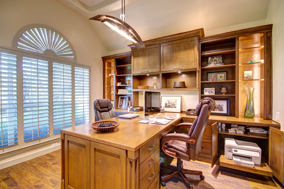 Example of a mid-sized arts and crafts built-in desk medium tone wood floor study room design in Austin with beige walls and no fireplace