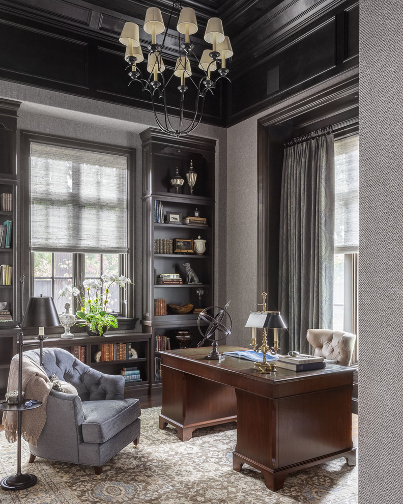 Ejemplo de despacho tradicional de tamaño medio sin chimenea con paredes grises, suelo de madera en tonos medios, escritorio independiente y suelo marrón