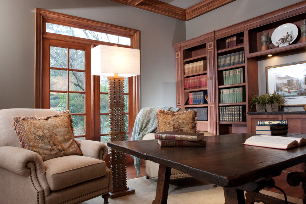 Пример оригинального дизайна: домашняя библиотека среднего размера в классическом стиле с серыми стенами, темным паркетным полом, отдельно стоящим рабочим столом и коричневым полом без камина