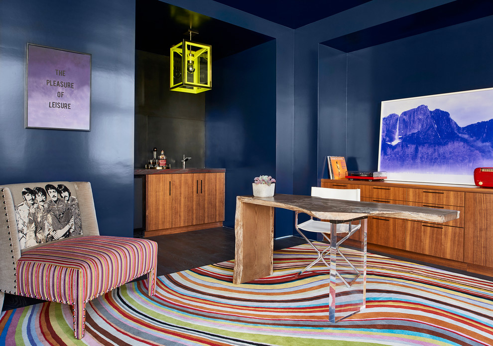 Diseño de despacho actual de tamaño medio con paredes azules, suelo de madera oscura y escritorio independiente