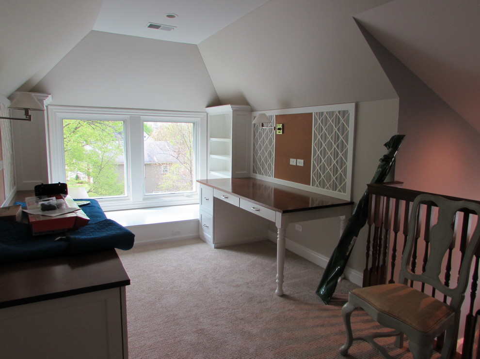 This is an example of a medium sized victorian craft room in Chicago with beige walls, carpet, no fireplace, a built-in desk and beige floors.