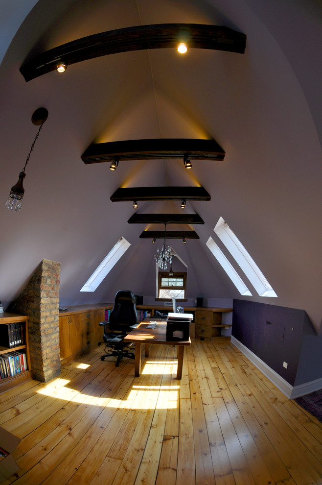Idéer för arbetsrum, med lila väggar, mellanmörkt trägolv och ett fristående skrivbord