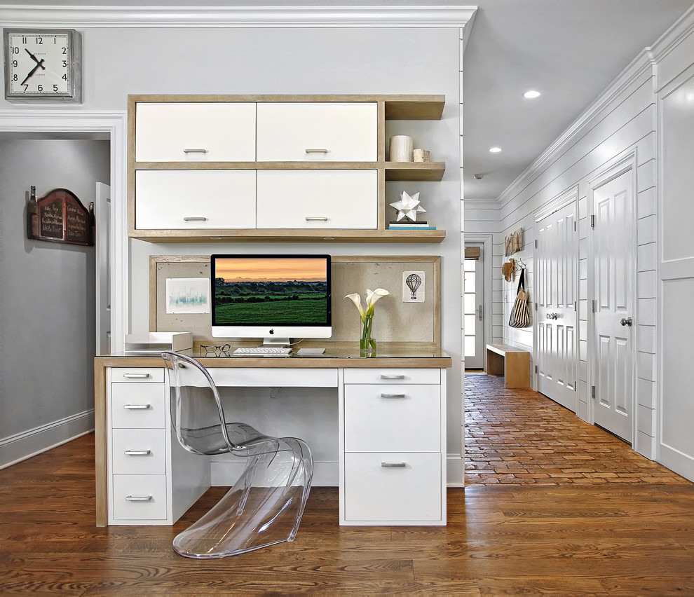 Idéer för ett litet maritimt arbetsrum, med vita väggar, mellanmörkt trägolv och ett inbyggt skrivbord