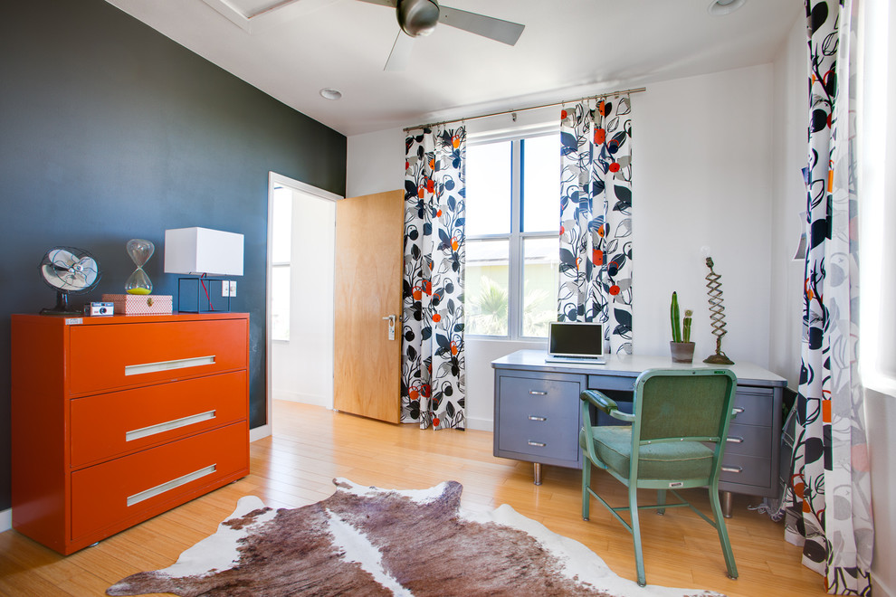 Inspiration for an eclectic freestanding desk medium tone wood floor home office remodel in Austin with white walls