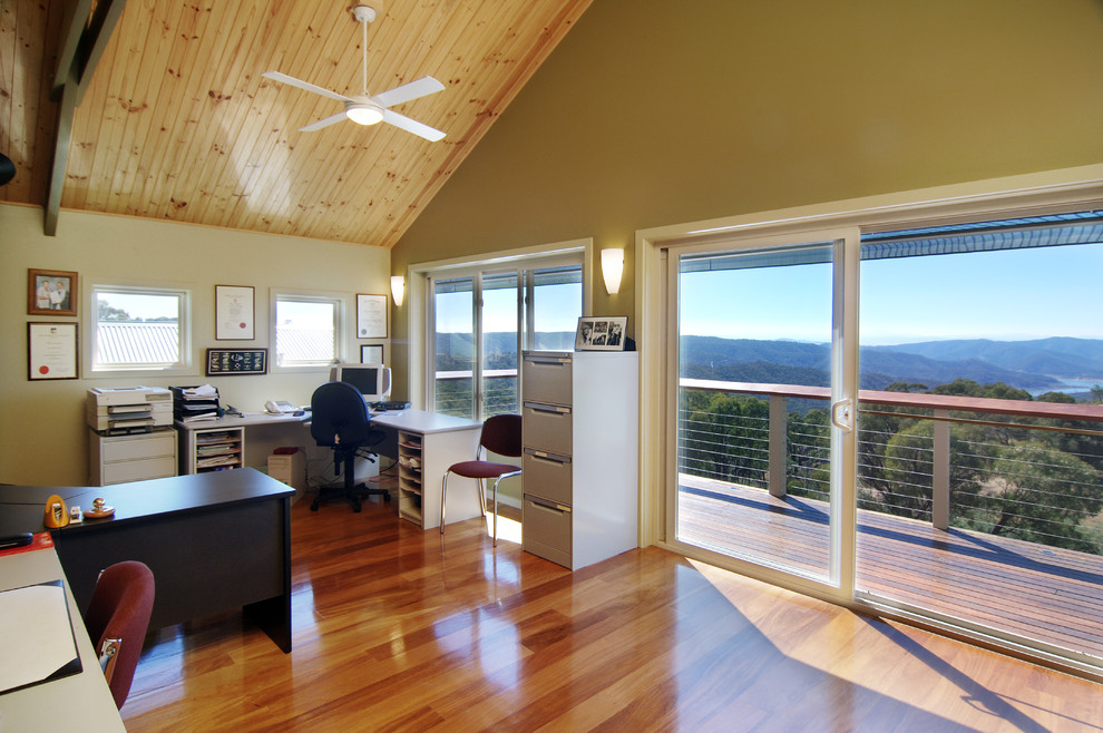 Imagen de despacho clásico sin chimenea con suelo de madera clara y escritorio independiente