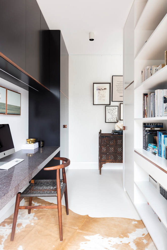 Esempio di un piccolo studio minimal con libreria, pareti bianche, scrivania incassata e pavimento bianco
