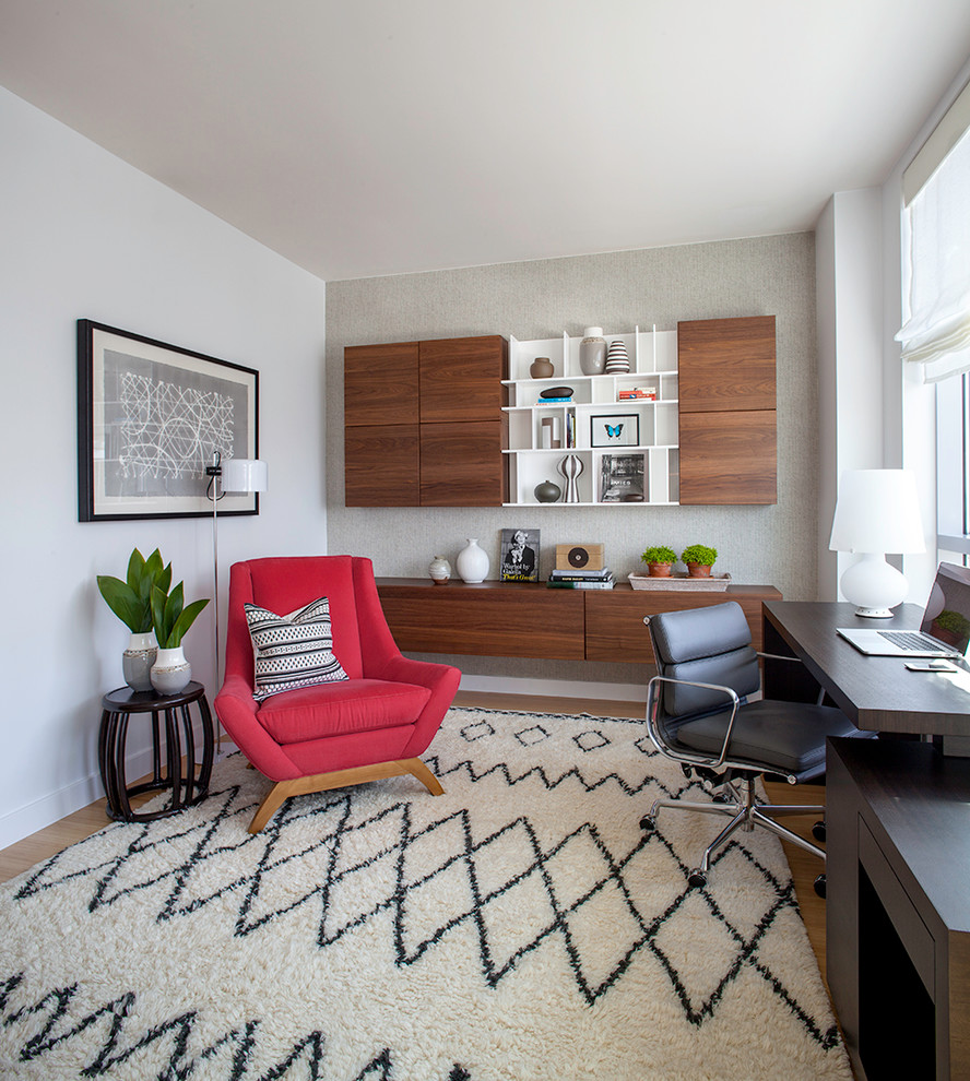 Modelo de despacho contemporáneo de tamaño medio con paredes blancas, suelo de madera en tonos medios y escritorio independiente