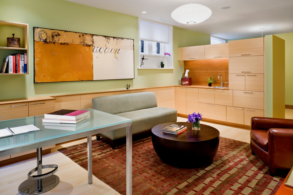 Réalisation d'un bureau design avec un mur vert, parquet clair et un bureau indépendant.