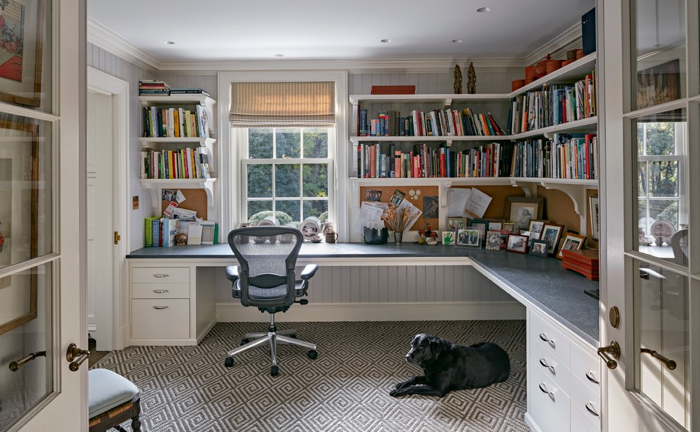 Inspiration för stora klassiska hemmabibliotek, med heltäckningsmatta, ett inbyggt skrivbord och grå väggar