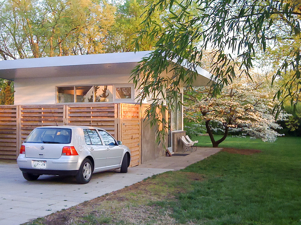 На фото: маленькая домашняя мастерская в стиле модернизм с белыми стенами и бетонным полом для на участке и в саду с