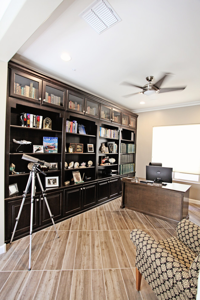 Exemple d'un bureau tendance de taille moyenne avec une bibliothèque ou un coin lecture, un mur gris, un sol en carrelage de porcelaine, aucune cheminée, un bureau intégré et un sol gris.