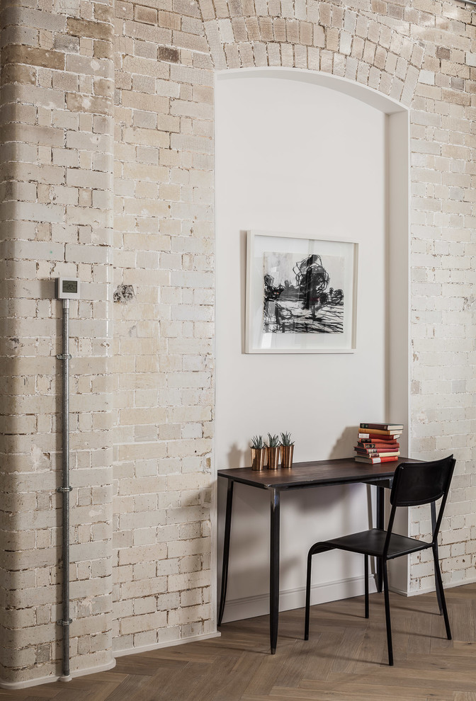 Industrial Arbeitszimmer mit weißer Wandfarbe, Arbeitsplatz, braunem Holzboden und freistehendem Schreibtisch in London