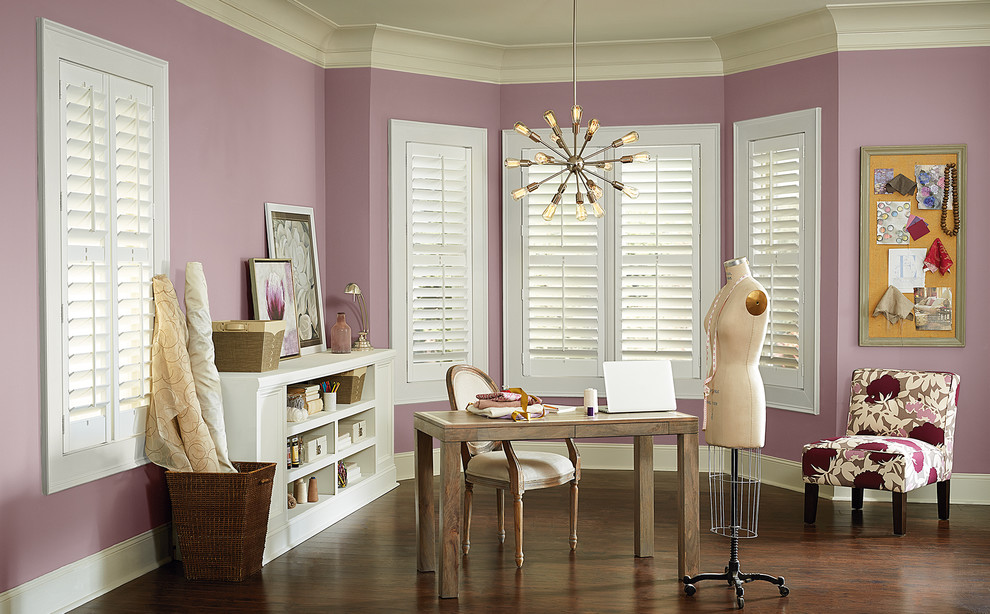 Imagen de sala de manualidades clásica renovada con paredes púrpuras, suelo de madera oscura y escritorio independiente