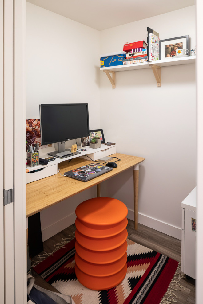 Immagine di un piccolo studio minimalista con pareti bianche, pavimento in vinile, scrivania autoportante e pavimento marrone