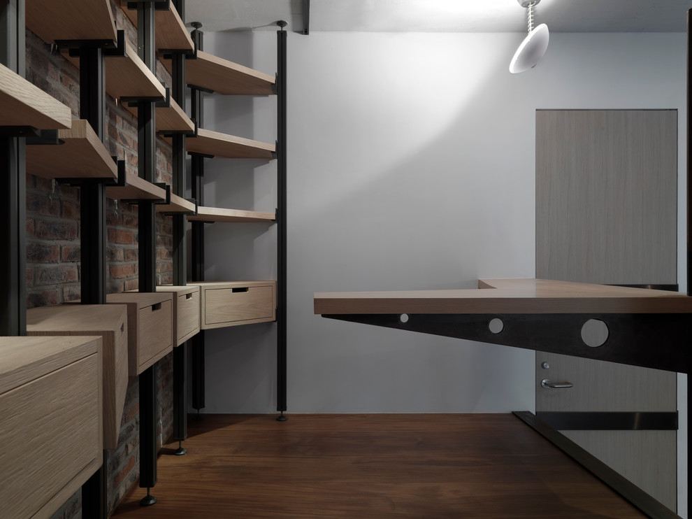 Foto di un piccolo studio industriale con libreria, pareti marroni, pavimento in legno massello medio, scrivania incassata e pavimento marrone