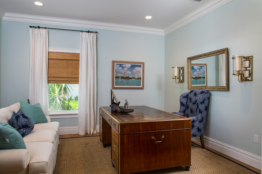 Diseño de despacho costero de tamaño medio sin chimenea con paredes azules, suelo de madera en tonos medios y escritorio independiente