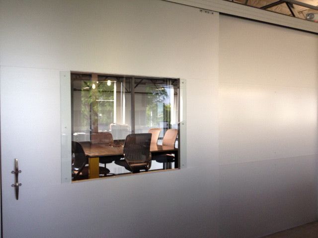 На фото: большой кабинет в стиле лофт с серыми стенами и отдельно стоящим рабочим столом с